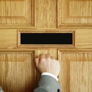 bigstock-businessman-knocking-on-a-door-87571403
